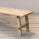 Wooden outdoor bench on a wooden floor against a plain wall