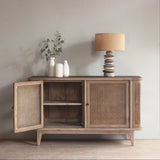 Reclaimed pine wood sideboard with open rattan doors in a room with a lamp and plant.