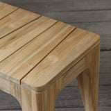 Wooden bench with slatted top on a wooden floor.