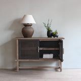 Reclaimed pine wood sideboard with a lamp and plants in a room setting