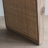 Reclaimed pine wood table leg with rattan panel on a light wooden floor