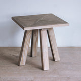 Pine wood side table with a mozaic patterend top on a wooden floor.