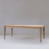 Outdoor dining table with slatted top on a wooden floor.