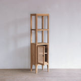 Wooden bathroom tall cabinet with rattan door in a minimalistic room