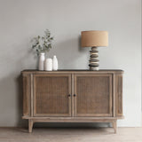 Reclaimed pine wood sideboard with rattan doors in a room with a lamp and plant.