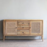 Wooden sideboard with rattan doors in a minimalistic room.