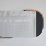 Squoval mirror with wooden border on a light gray background