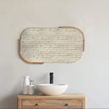 Wooden bathroom vanity with squoval mirror and sink against a plain wall.