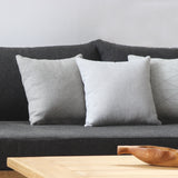 Decorative pillows on a greyish black sofa.
