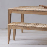 Wooden dining table and bench set with slatted top on a wooden floor.
