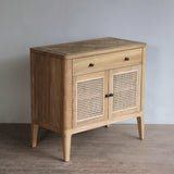 Wooden sideboard with rattan doors against a plain wall.