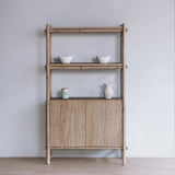 Reclaimed pine wood tall cabinet with decorative items against a plain wall