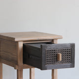 Wooden side table with a drawer on a plain background