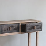 Reclaimed pine wood console table with rattan drawers against a plain wall