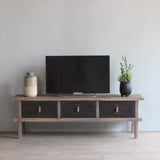 TV Cabinet with decorative items against a plain wall.