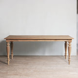 Wooden table with turned legs in a minimalistic room.