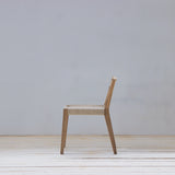Wooden chair on a wooden floor with a light gray wall background