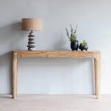Front view of Arch Console Table with Pebbles Lamp and decorative plants on top of it.
