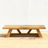 Wooden coffee table on a wooden deck with a white background