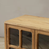 Wooden sideboard with framed glass panels on a plain background
