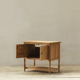 Wooden cabinet with open doors on a wooden floor against a beige wall