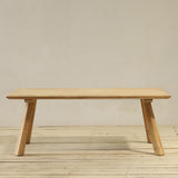Wooden outdoor table on a wooden floor with a plain wall background