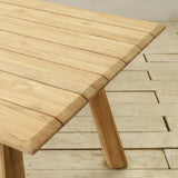 Wooden outdoor table with slatted top on a wooden floor.