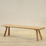Wooden outdoor bench on a wooden floor with a plain background