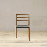 Outdoor chair with synthetic rattan seating on a wooden floor.