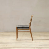 Outdoor chair with synthetic rattan seating on a wooden floor.