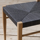 Outdoor chair with synthetic rattan seating on a wooden floor.