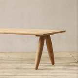 Wooden table with a minimalist design on a wooden floor.