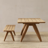 Wooden table and bench set on a wooden floor with a plain background