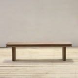 Reclaimed pine wood bench on a wooden floor with a plain background