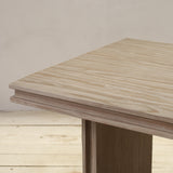 Reclaimed pine wood table with a light finish on a wooden floor.