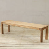 Wooden bench on a wooden floor with a plain wall background