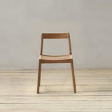 Wooden chair on a wooden floor with a white wall background