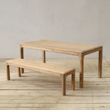 Wooden table and bench set on a wooden floor with a plain background