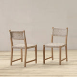 Two wooden chairs with woven backrests on a wooden floor against a plain wall.
