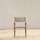 Wooden armchair with woven backrest on a wooden floor and beige wall background