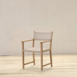 Wooden armchair with woven seat and backrest on a wooden floor and light gray wall background