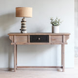 LUNAR Rattan Console Table with Pebbles Lamp and decorative plant on top of it.