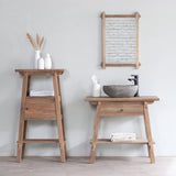 Vanity Small Cabinet next to Vanity Bathroom Cabinet and mirror. There are white vases and towels on Vanity Small Cabinet while there is a white tissue holder and a stone sink on Vanity Bathroom Cabinet.