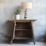Front view of Vanity Cabinet with doors opened. There's Pebbles Lamp and decorative plant on top of it.