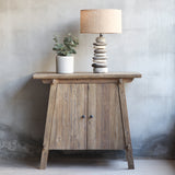 Front view of Vanity Cabinet with Pebbles Lamp and decorative plant on top of it.
