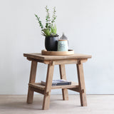 Vanity End Table with wooden tray, decorative items, and books on it.