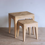 Wooden end table on a plain floor with a light gray wall background