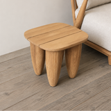 Wooden side table next to a gray sofa on a wooden floor.