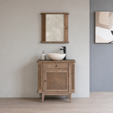 Bathroom vanity with wooden cabinet, mirror, and sink against a gray wall.