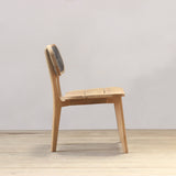 Outdoor wooden chair with rattan backrest on a wooden floor against a plain wall